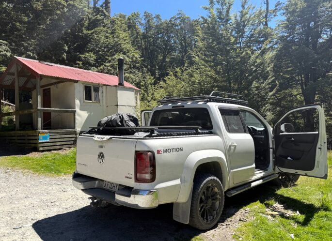 4WD parked beside a remote backcountry hut during the Back Roads fishing expedition