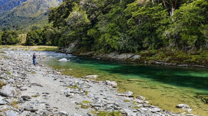 Angler fishing a clear alpine river on a Queenstown HELIfish adventure